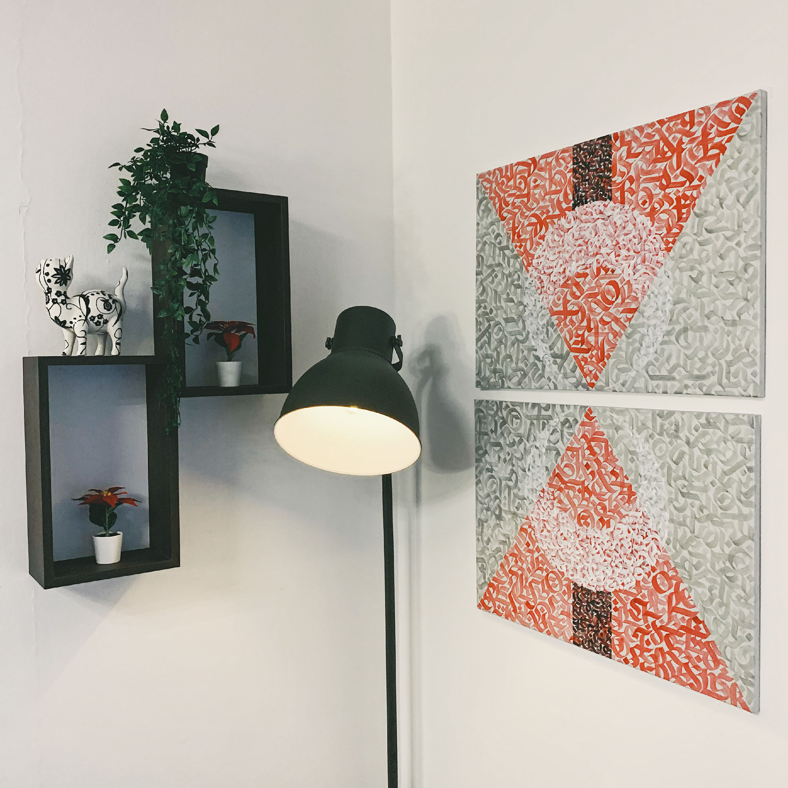 A shot of a canvas artwork made in the living room. Abstract calligraphy within geometric shapes divided into two 50x70 canvases painted with acrylic paint.